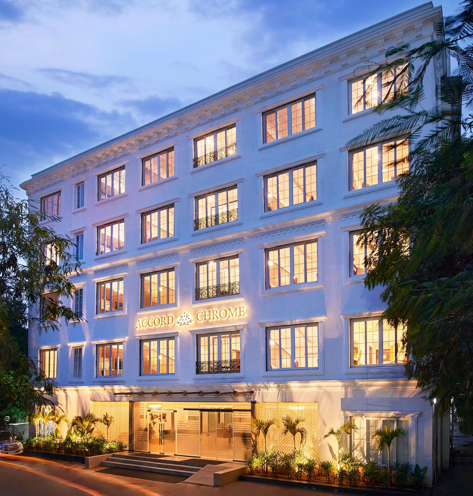 An image of building surrounded by trees on the road